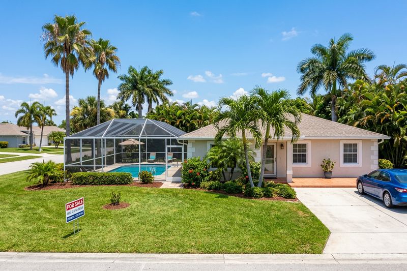 A Florida home with a backyard pool and a For Sale sign