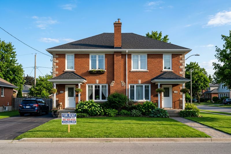 A house with a For Rent sign on the front lawn